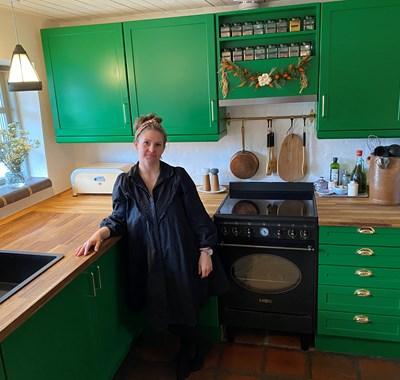 Carina bor med grønt køkken og lyserødt gulv